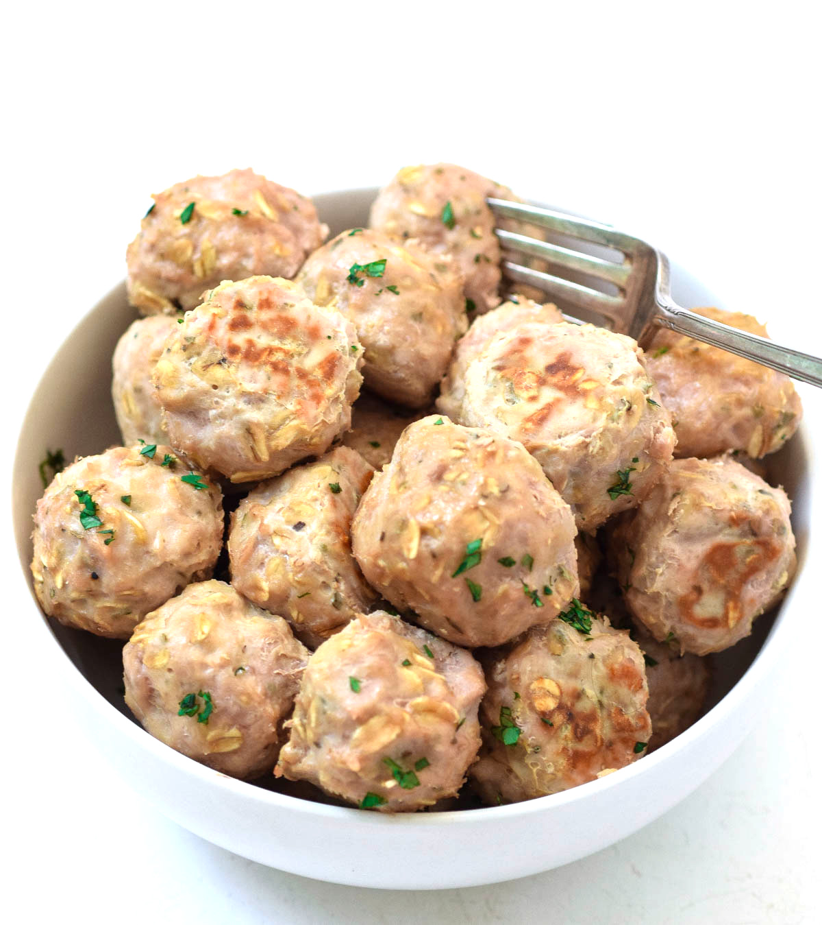 cooked meatballs in bowl with fork