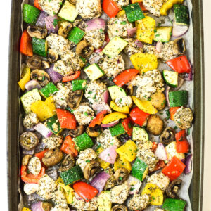 overhead view of italian chicken and veggies baked on a sheet pan