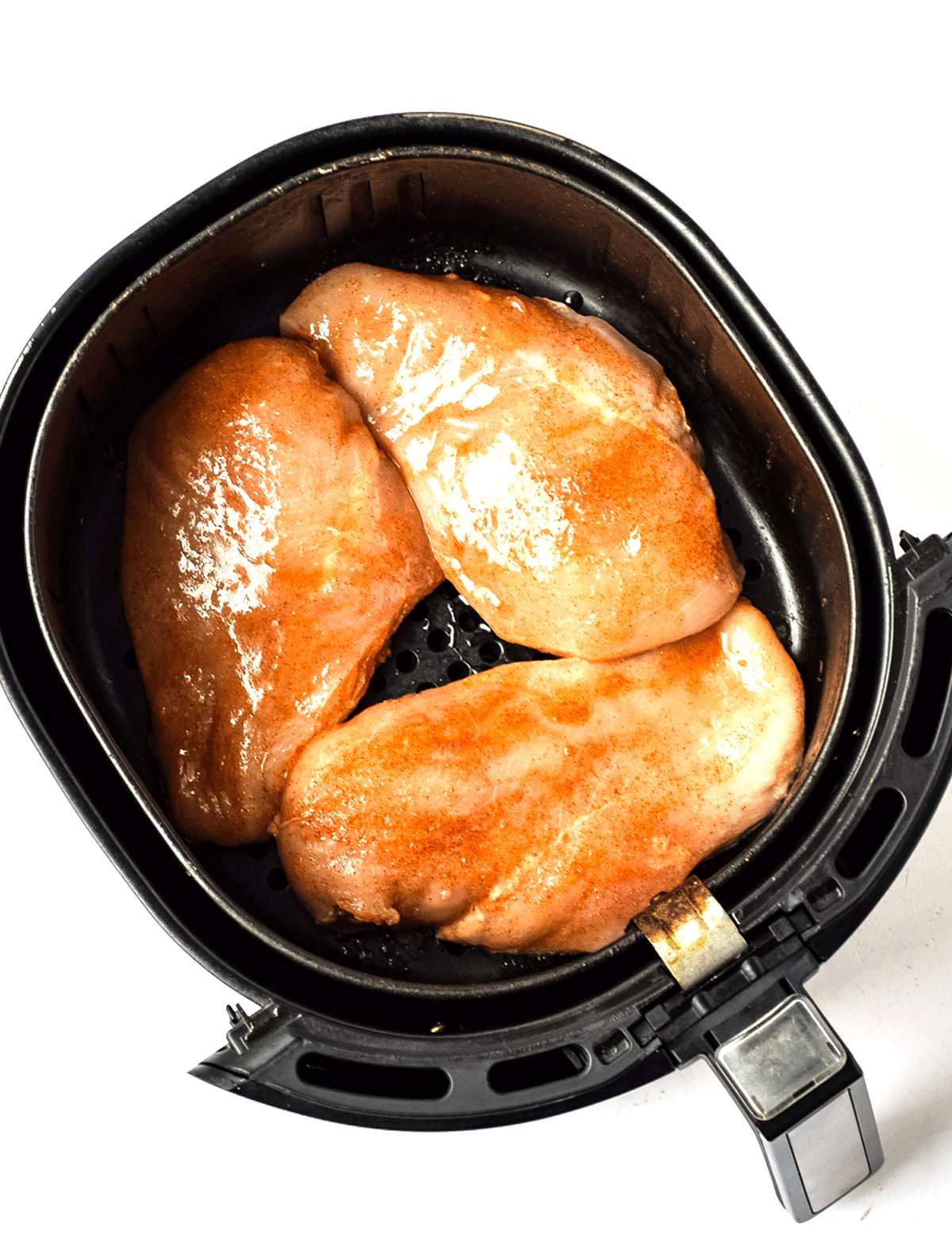 marinated chicken breasts arranged in air fryer