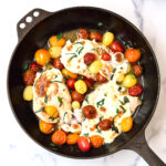 large skillet with caprese chicken and tomatoes