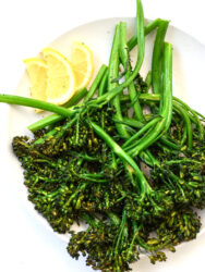 air fried broccolini on a plate with lemon slices