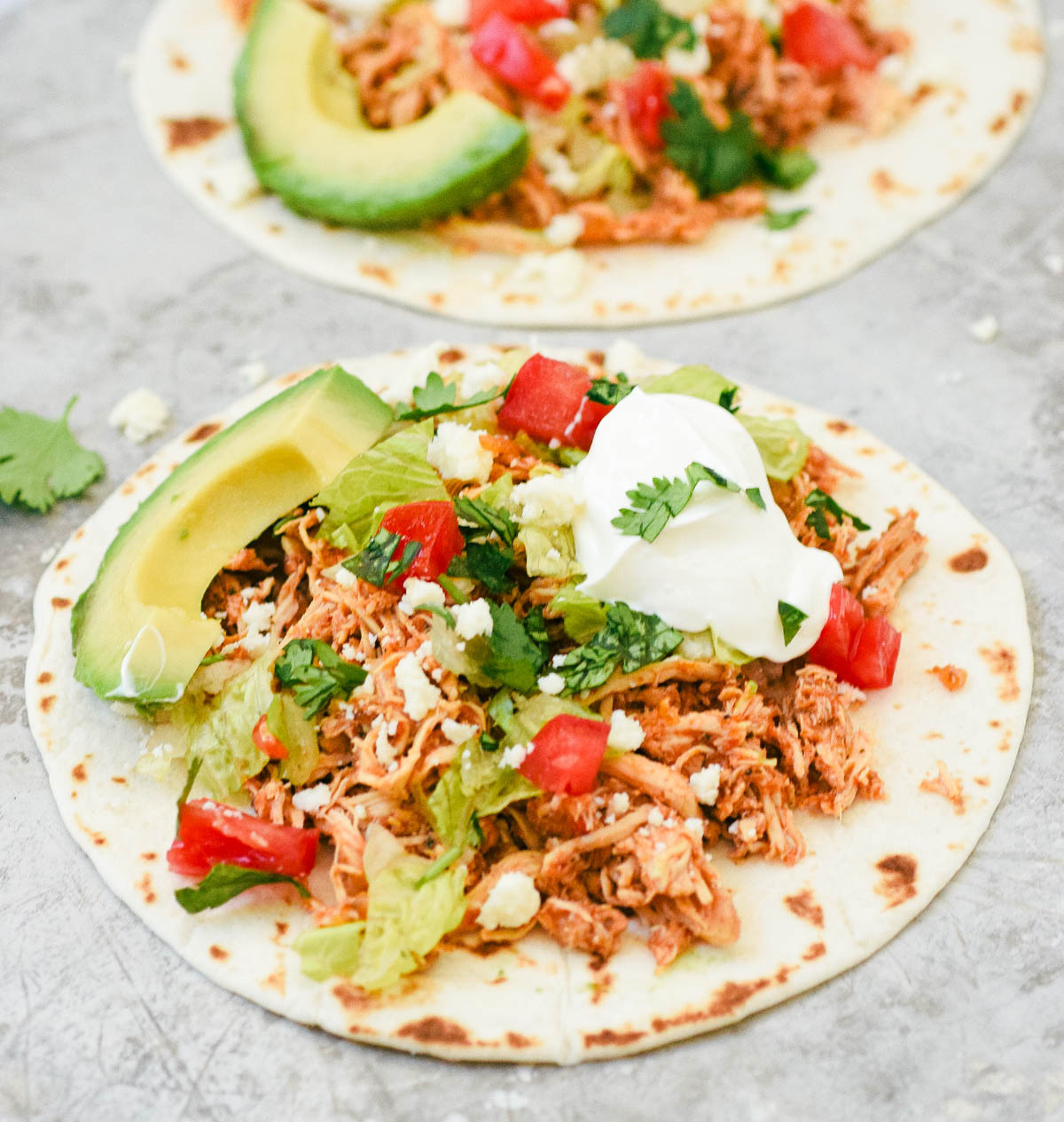 close up of chicken taco meat on a tortilla with toppings
