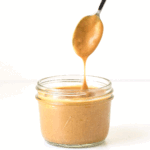 spoon dipped in a small jar of thai peanut dressing