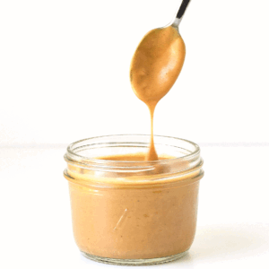 spoon dipped in a small jar of thai peanut dressing