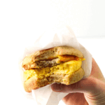 hand holding high protein breakfast sandwich with bite out of it